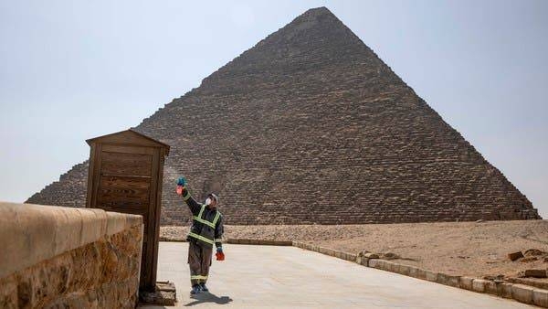 Municipal workers sanitize the areas surrounding the Giza Pyramids complex. -- File photo
