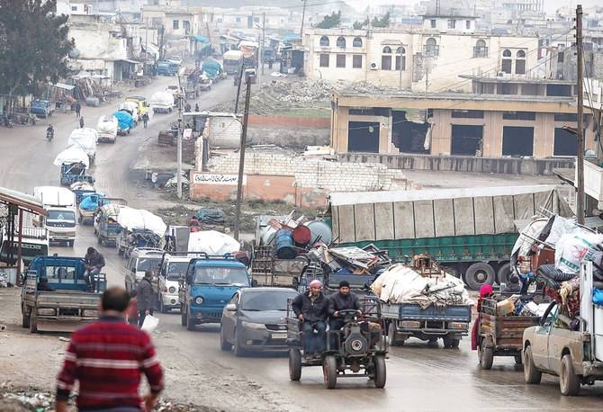 A convoy of trucks transporting Syrians and their belongings drives through the village of Al-Mastuma, in the northern countryside of Idlib province. -- Courtesy photo