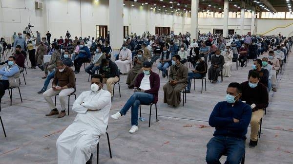 Expatriates wait for mandatory coronavirus testing in a makeshift testing center in Mishref, Kuwait. -- File photo
