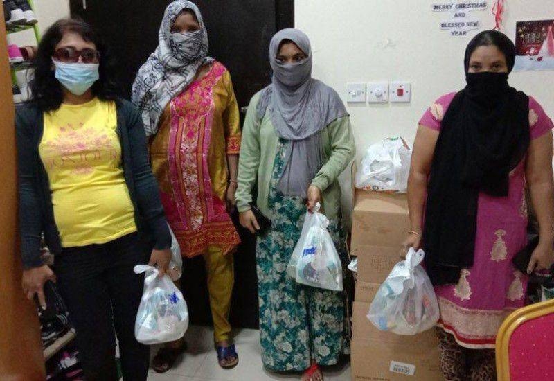 Jobless women in Bahrain carry charity food parcels distributed as part of a public relief initiative. -- Courtesy photo