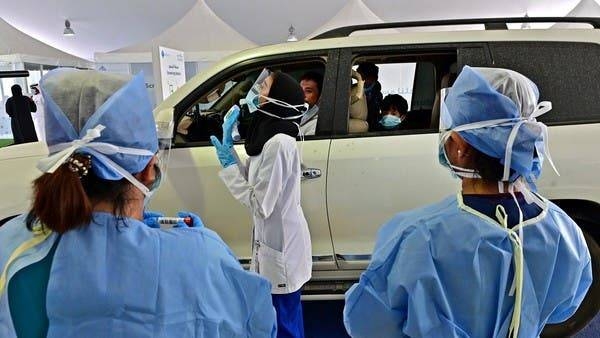 A nurse instructs a driver about the procedure of the coronavirus testing in front of a drive thru verification center in Abu Dhabi in this file picture. — Courtesy photo
