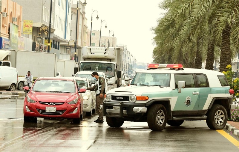 A policeman wearing a protective face mask blocks the road during curfew hours in Eastern Province to prevent the spread of the coronavirus. — SPA