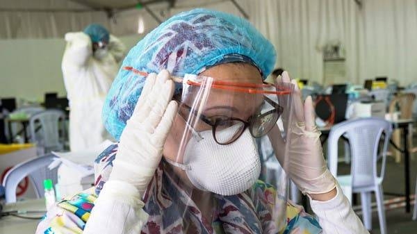 A Kuwaiti doctor adjusts her protective face shield ahead of the arrival of a planeload of repatriated Kuwaiti citizens at a makeshift field testing center at Kuwait Airport, in Kuwait City. -- Courtesy photo