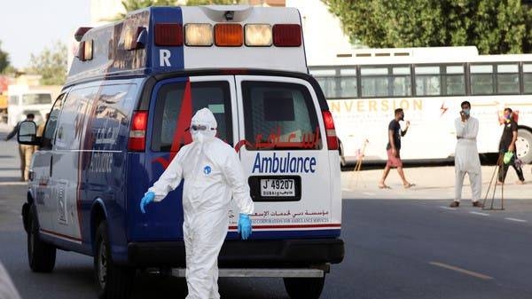 A first responder wearing a protective suit arrives to take a patient in the Al Quoz industrial district of Dubai. -- File photo
