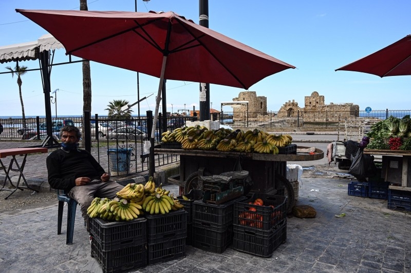 In the normally bustling Mar Mikhael neighborhood of Beirut, a fruit seller keeps his doors open while a butcher prepares to shut down his shop. -- Courtesy photos
