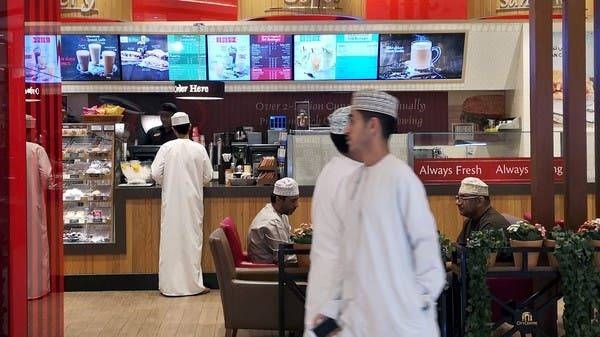 Omani men pass in front of Tim Hortons in City Center Mall in Muscat. -- Courtesy photo
