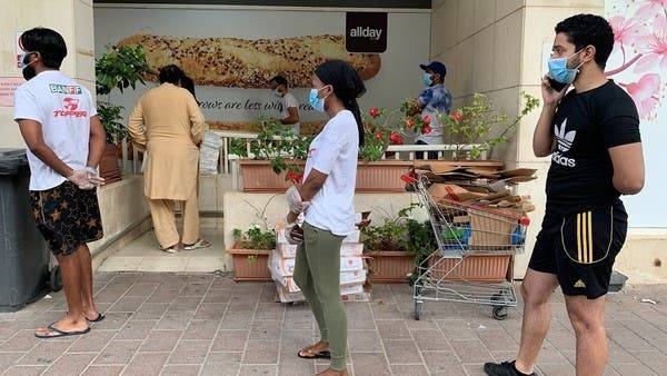 People keep distance in a line outside a supermarket to prevent the spread of the coronavirus disease in Dubai. -- File photo
