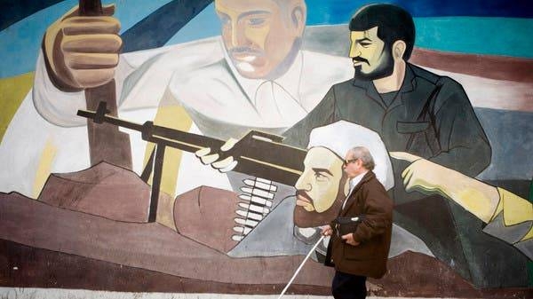 
A blind man walks past a mural on a wall at Palestine Square in Tehran. — File photo