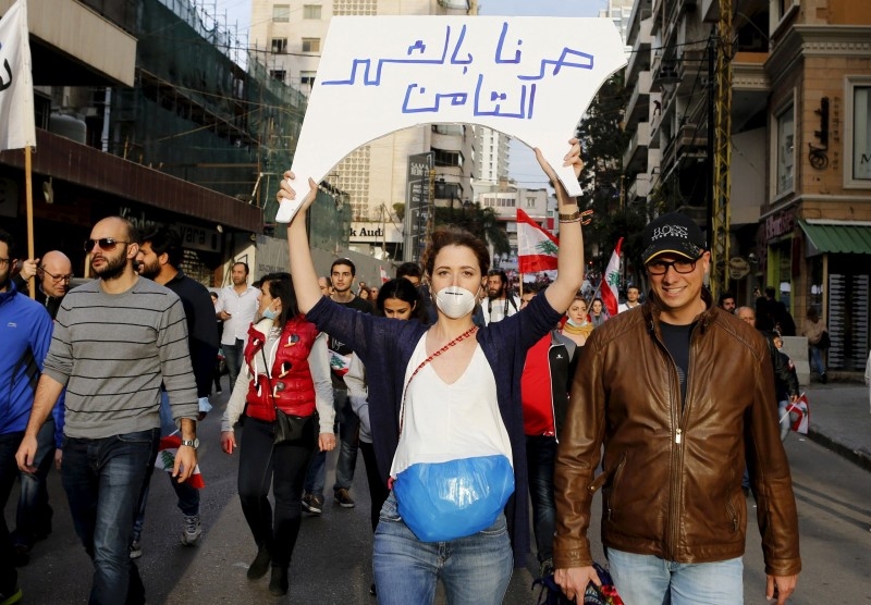 A protester, wearing a garbage bag and holding up a sign, takes part in a protest against what demonstrators say is the government's failure to resolve a crisis over rubbish disposal in Beirut, Lebanon March 12, 2016.

