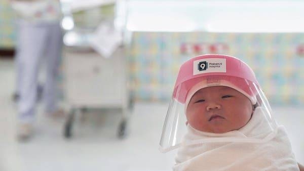 A newborn baby is seen wearing a protective face shield at a hospital in Bangkok. — File photo