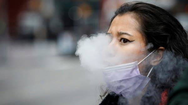 A woman exhales after vaping in Times Square in New York City. -- Courtesy photo
