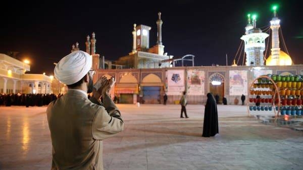 A cleric prays outside the Fatima Masumeh shrine in the city of Qom in this file photo.

