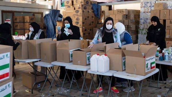 
Kuwaiti volunteers wear protective masks as they fill charity boxes with essential household supplies to distribute to the needy in Adeliah, Kuwait. -- Courtesy photo
