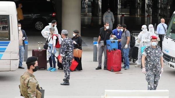 Lebanese people, who were stranded abroad by coronavirus lockdowns, are pictured wearing face masks and gloves as they hold their luggage upon arrival at Beirut's international airport in April. -- Courtesy photo