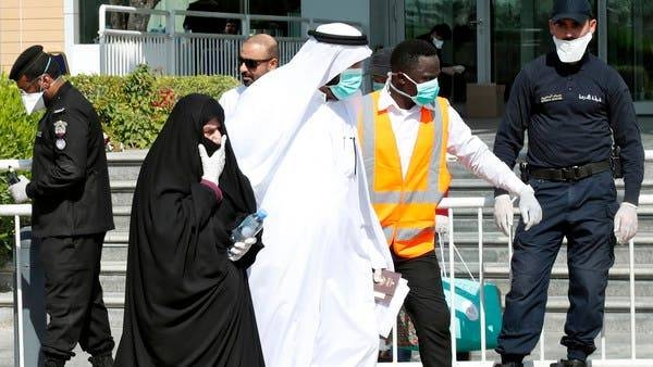 Qatari police stand outside a hotel in Doha as a medical worker walks alongside people wearing protective masks over fears of coronavirus in this file picture. — Courtesy photo