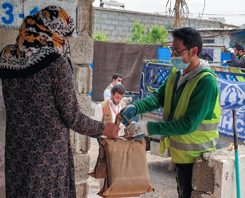 UNHCR and partner staff distribute sanitary kits to a Syrian woman, one of 13,000 refugees living at Darashakran camp in Erbil, Kurdistan Region of Iraq. — courtesy photo by UNHCR / Shaza Shekfeh