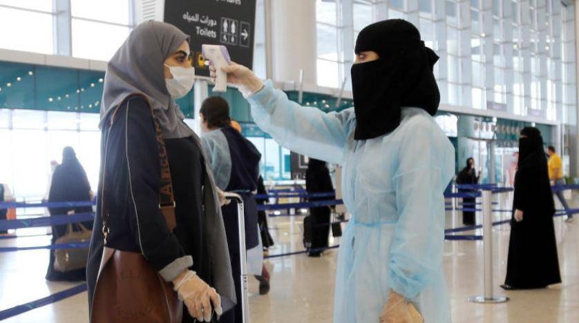 A security woman checks the temperature of a woman at Riyadh's King Khalid International Airport on Sunday. — Courtesy photo