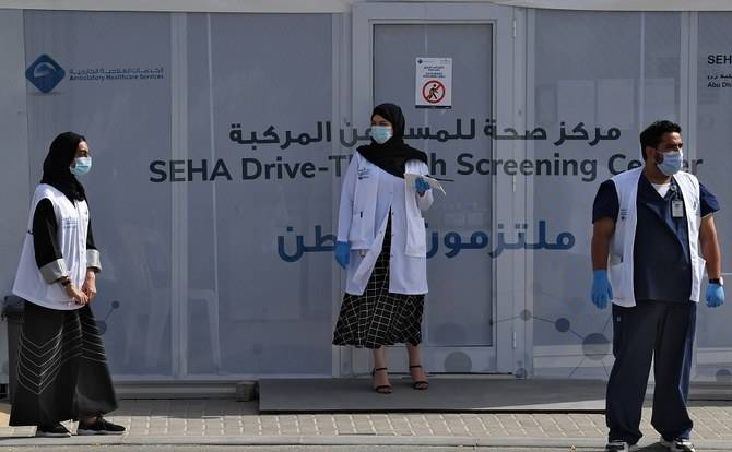 Medical volunteers wait outside a drive-through COVID-19 coronavirus testing center in Al-Khawaneej district of Dubai in this file photo.
