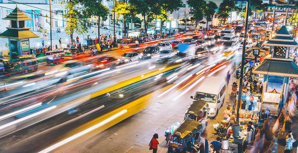 A time-lapsed scene of a busy street at night in Bangkok, Thailand. — courtesy Unsplash/Dan Freeman