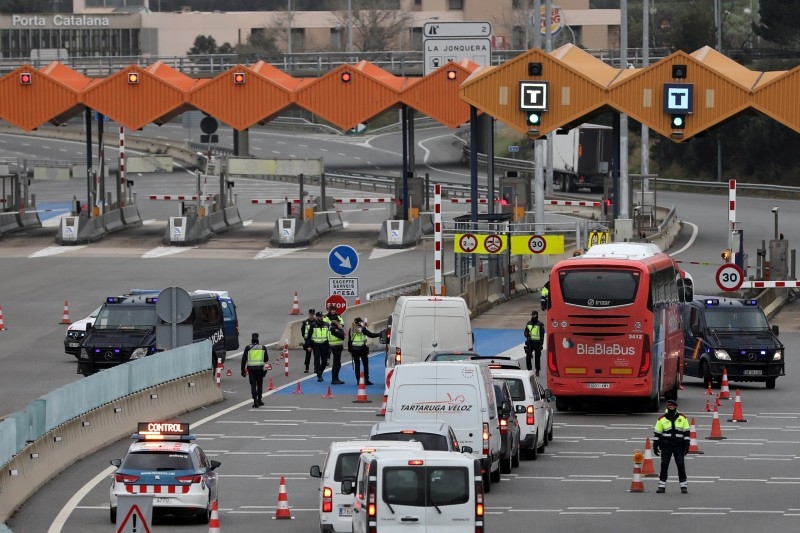 Border police officers check vehicles at the last toll gate entering Spain from France. — Courtesy photo
