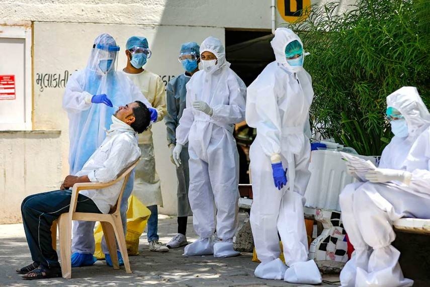 A team of medics collect swab sample of a resident for COVID-19 test after many positive coronavirus cases were detected in the area, during the nationwide lockdown, in the western city of Ahmedabad. — Courtesy photo