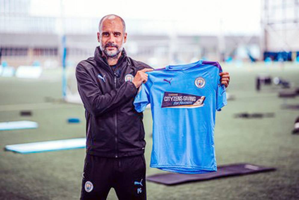 Manchester City manager Pep Guardiola shows off matchday shirt for Premier League return.