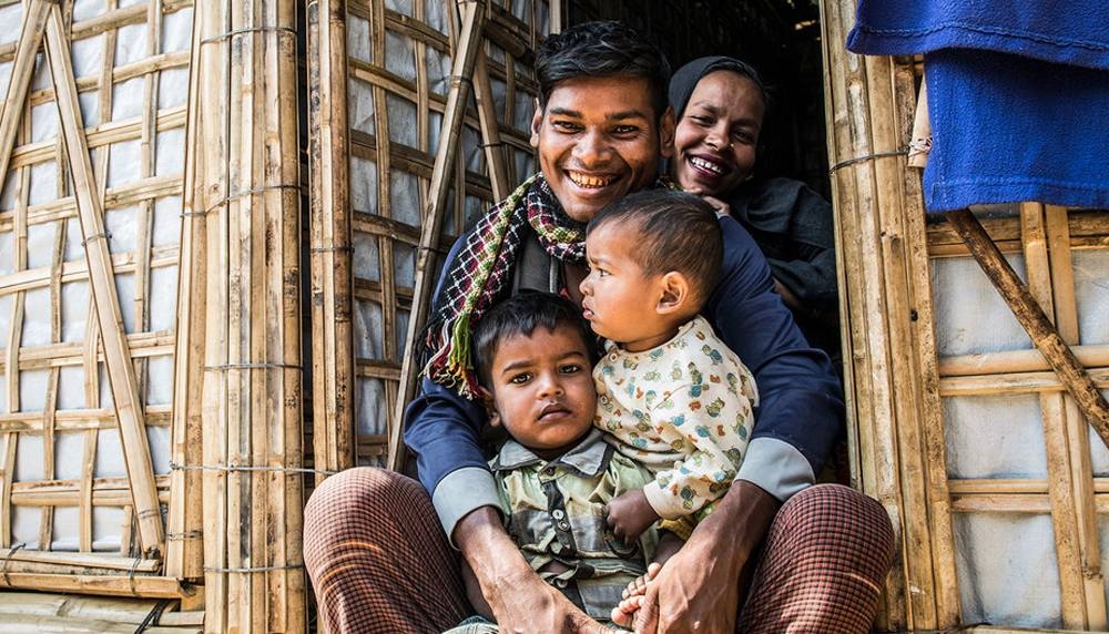 A Rohingya refugee family sit in the doorway of their new monsoon-ready shelter in Cox’s Bazar, Bangladesh. — courtesy UNHCR/Vincent Tremeau