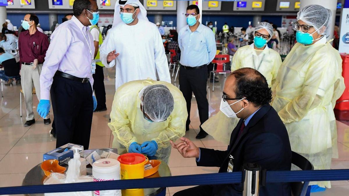 Health workers test an Indian citizen at Dubai International Airport before he boards a repatriation flight. — Courtesy photo
