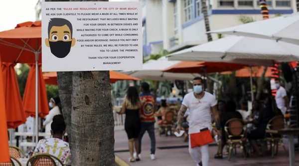 A sign informs customers at the Edison Hotel restaurant about wearing a protective face mask during the coronavirus pandemic, along Ocean Drive in Miami Beach, Fla. Masks are mandated both indoors and outdoors in Miami Beach. People found not wearing a mask are subject to a civil fine. — Courtesy photo