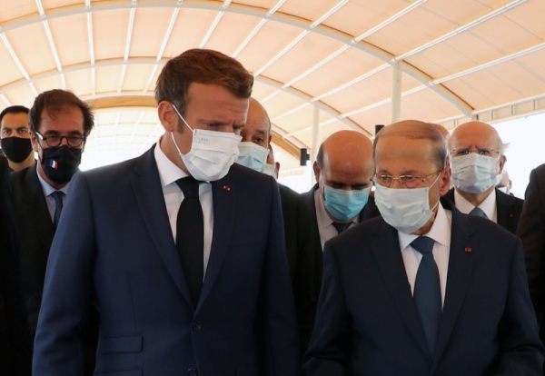 French President Emmanuel Macron, left, walks with Lebanese President Michel Aoun at Rafic Hariri International Airport in Beirut on Thursday. — Courtesy photo