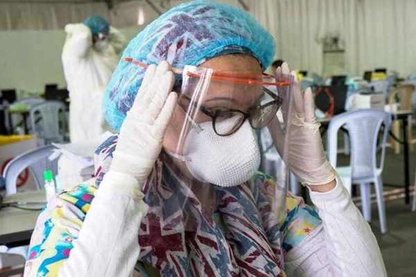 A doctor adjusts her protective face shield ahead of the arrival of a planeload of repatriated Kuwaiti citizens at a makeshift field testing center in Kuwait City. — File photo