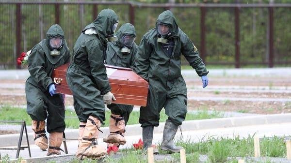Grave diggers wearing protective suits carry a coffin during the burial of a coronavirus victim at a cemetery on the outskirts of Moscow in this file photo.