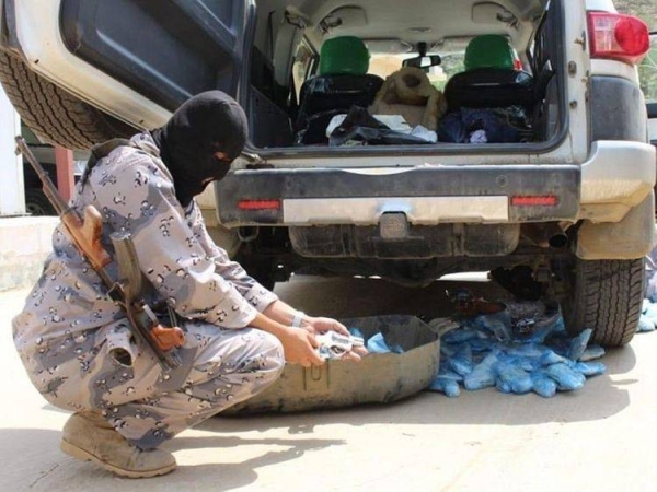 A guard picks through the haul of seized narcotics. — SPA photo
