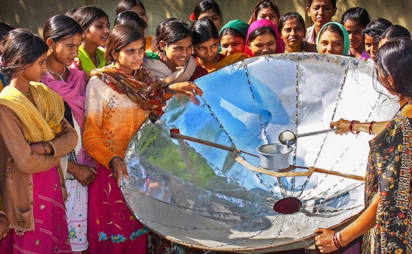 In India, a woman demonstrates how to use a solar dish for cooking. — courtesy UNDP India