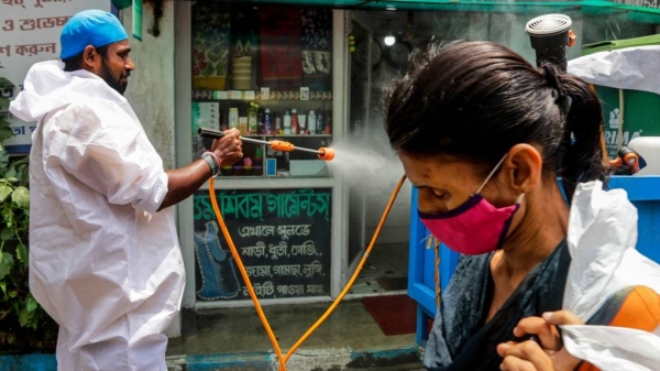 A civic worker sprays sanitizers in front of a shop in the eastern Indian city of Kolkata, Sunday. — Courtesy photo
