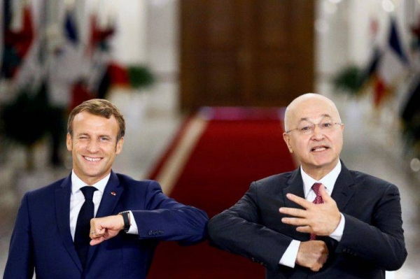 French President Emmanuel Macron and Iraq's President Barham Salih greet each other with an elbow bump as they attend a news conference in Baghdad, Wednesday. — Courtesy photo