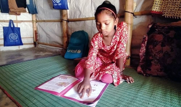 
A nine-year-old studies at her shelter in a Rohingya refugee camp in southern Bangladesh. She is supported by her mother and teacher as the education center at the camp is closed due to COVID. — courtesy UNICEF