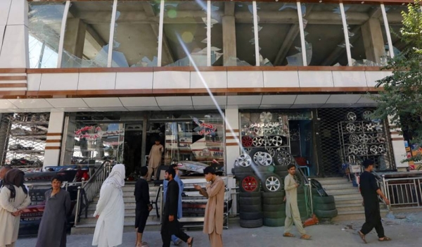 File photo shows shopkeepers in Kabul, Afghanistan, gather in front of a building which bore the brunt of a July 1, 2019, attack claimed by the Taliban. — courtesy UNAMA/Fardin Waezi