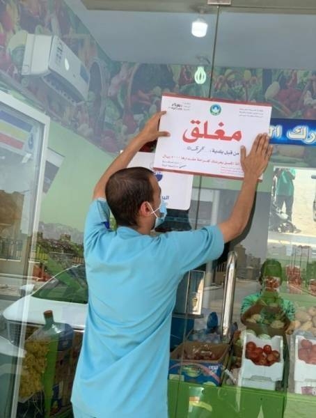 A worker puts closed sign on a shop in Jeddah in an earlier campaign. — File photo
