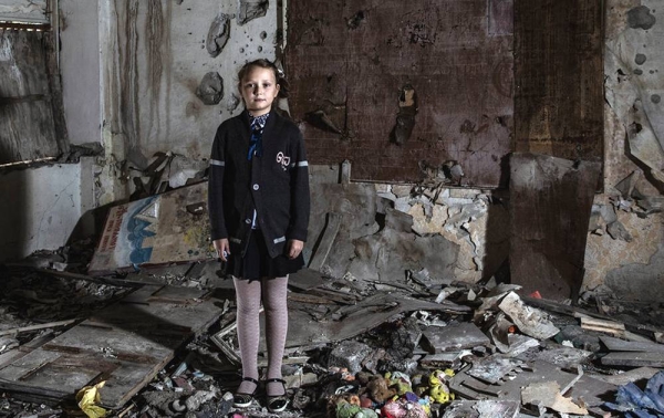 Masha Khromchenko stands in the kindergarten classroom that took a direct hit from a shell in the Luhansk region, Ukraine. (Sept. 23, 2018) — courtesy UNICEF/Christopher Morris