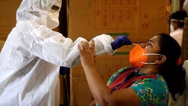 A health worker collects a swab sample from a woman in Mumbai. — File photo
