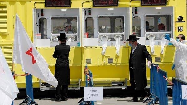 Ultra orthodox Jewish men stand by a COVID-19 testing station in occupied Jerusalem in this file photo.
