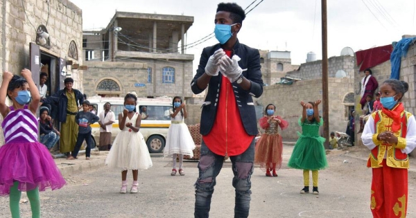 A seven-year-old girl is given a protective mask prior to a health screening in the informal settlement in Rome, Italy, where she lives. — courtesy UNICEF/Alessio Romenzi.