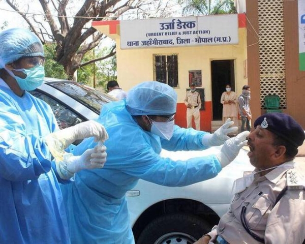Medics examine a policeman for COVID-19 in the Indian city of Bhopal. — File photo
