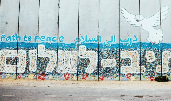 

A mural on a wall in Netiv HaAsara, Israel, that faces the Gaza border and reads Path to Peace in Hebrew, Arabic, and English. — courtesy Unsplash/Cole Keister