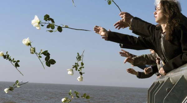 
Visitors throw white flowers into Rio de la Plata in Buenos Aires out of respect and remembrance for the tens of thousands of people who disappeared during Argentina's so-called 