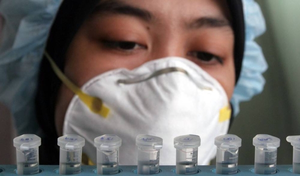 Indonesian health worker analyzing blood samples for influenza. — courtesy UN/file photo