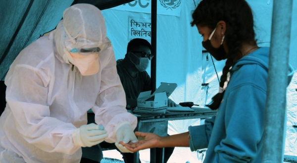 A health worker screens a young girl for COVID-19 at a temporary clinic set up next to a hospital in southern Nepal.  — courtesy UNICEF Nepal