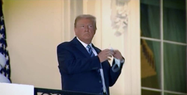 A video grab of US President Donald Trump on his return to the White House. He is caught standing on a flag-decked Truman Balcony.