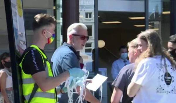 A Dutch volunteer hands out facemasks to people on a street as the Netherlands along with a string of other measures as the country attempts to curb rising coronavirus cases.
